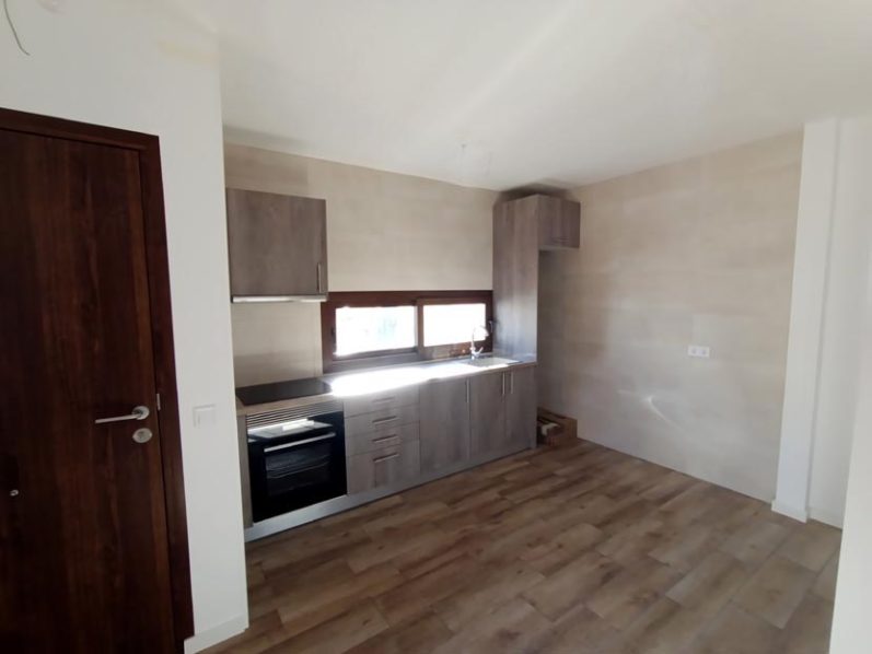 Cocina moderna con muebles de madera, electrodomésticos y buena iluminación natural.