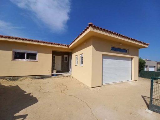 Casa unifamiliar de un solo piso con entrada y garaje, fondo despejado y cielo azul.