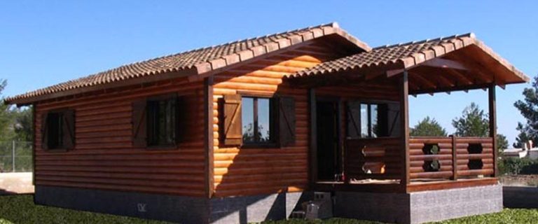 Casa prefabricada modelo Lieta de 70 m Casa de madera con porche, ventanas y tejas, ubicada en un entorno natural.