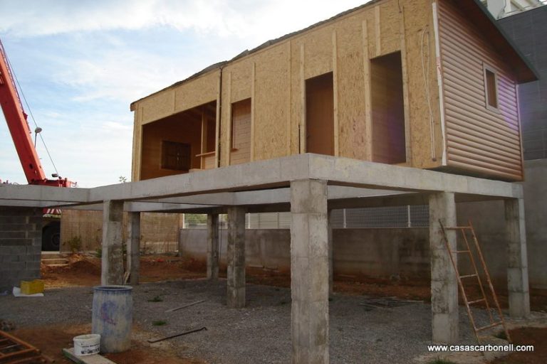 Estructura de casa prefabricada vivienda en construcción, elevada sobre bases de hormigón.